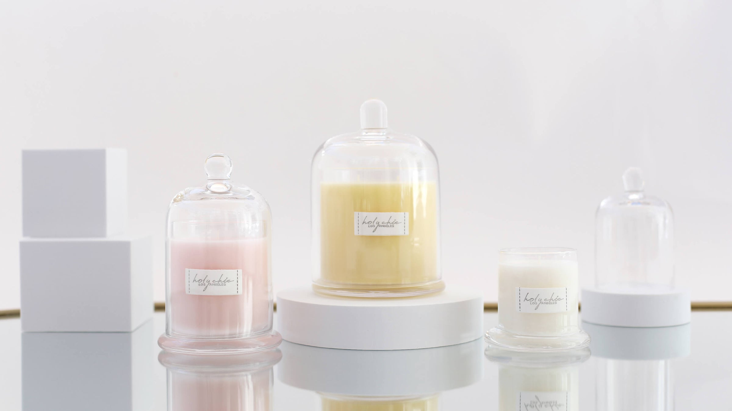 Scented candles in a clear glass containers with a cloche