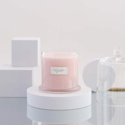A scented candle in a light pink color 