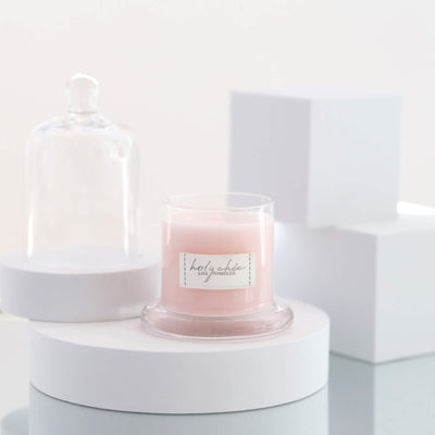 A scented candle in a light pink color 