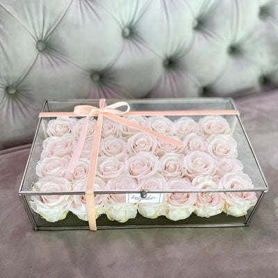 Forever roses arranged in a rectangular clear glass box 