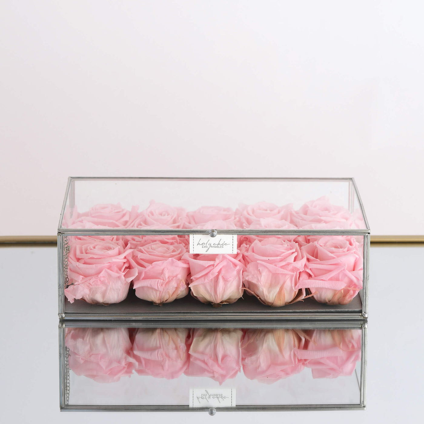 Forever roses arranged in a rectangular clear glass box 