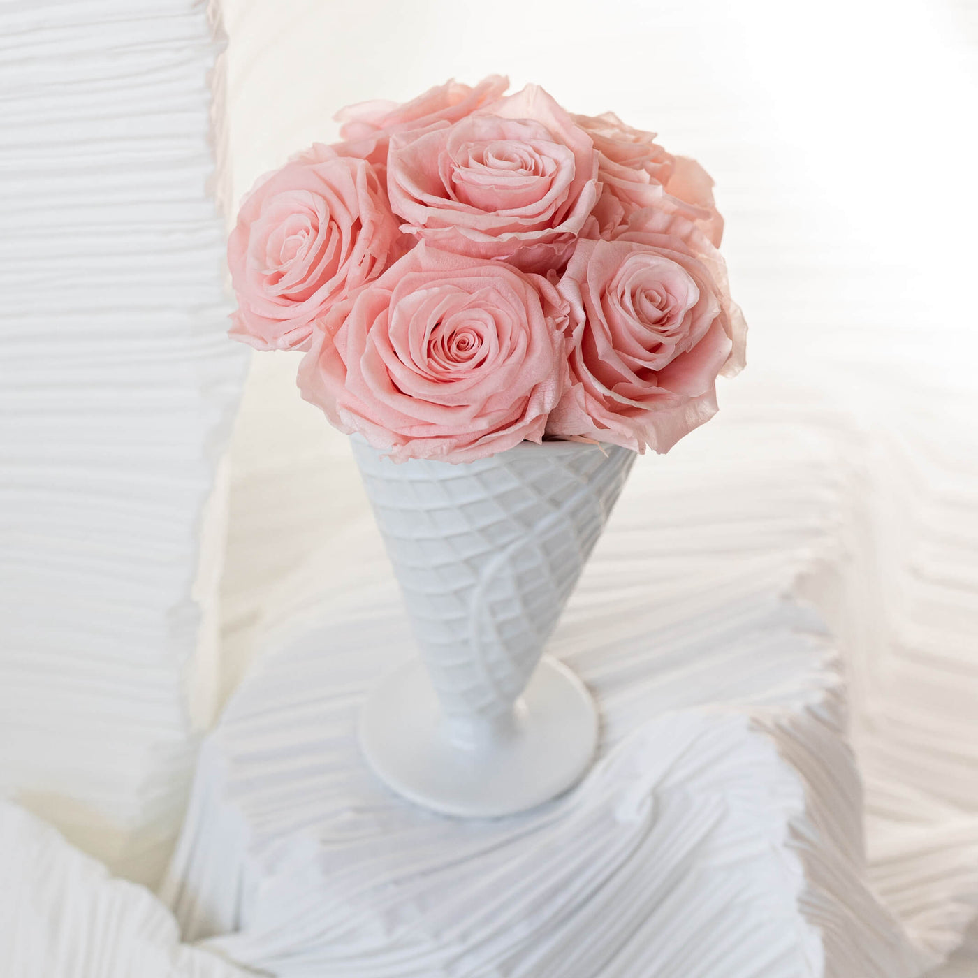 Forever roses arranged in a white ceramic vase